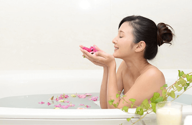 お風呂に入りながら花の香りを楽しむ女性